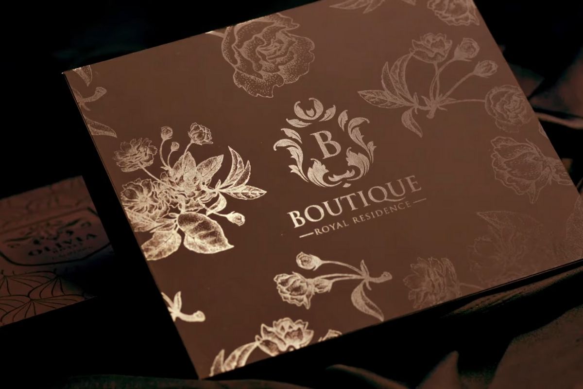 Luksuzna poklon kutija sa floralnim motivima i brendiranim logotipom na poklopcu